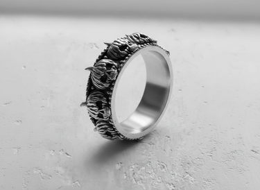 Angled view of handcrafted silver skull pumpkin ring displaying the smooth inner band and thick sterling silver construction