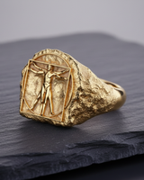 Gold variation of Vitruvian Man Ring showing detailed craftsmanship and classic proportions on stone