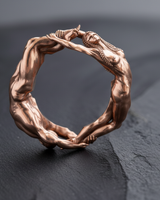 Close-up of intertwined hands and feet on handcrafted silver couple ring with rose gold finish option