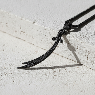 Black rhodium plated 925 sterling silver Zulfiqar sword necklace on textured stone background