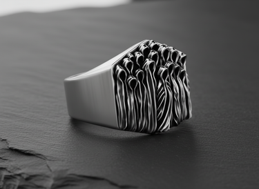Side profile of the handcrafted silver ghost ring, highlighting the sculptural depth of the huddled spirits on the band.