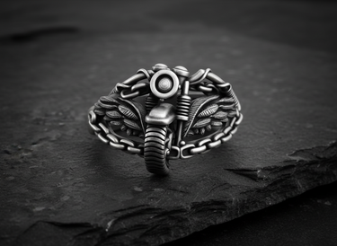 Front view of 925 sterling silver motorcycle ring with detailed tire and handlebars on stone surface