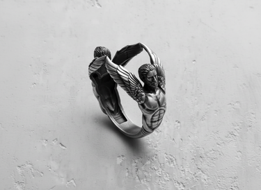 925 sterling silver angel sculpture ring featuring two winged figures reaching together on grey background