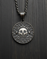 Oxidized 925 sterling silver skull coin pendant displayed on dark wooden texture