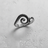 925 sterling silver octopus tentacle ring with spiral design and oxidized suction cups on textured white background