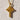 Close-up of golden Celtic cross pendant highlighting the detailed woven knotwork resting on a rustic background.