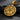 Gold vermeil round pendant featuring angry gorilla beating chest on black textured stone background
