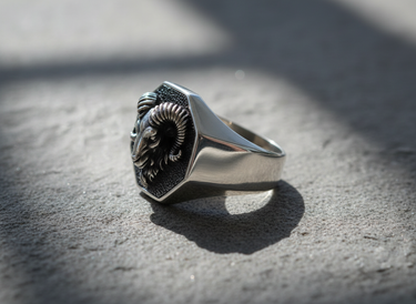 Side profile of handcrafted silver ram ring showing polished band thickness and raised relief design on stone