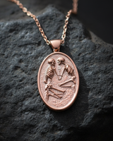 Rose gold plated silver skeleton lovers pendant featuring two skeletons facing each other on dark stone background