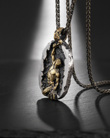 Angled view of handcrafted gold vermeil self creation pendant highlighting the hammer and rough rock texture