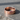 Rose gold organic band ring with red stone accents displayed in natural light on stone