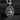 Oxidized 925 sterling silver Saint Clare pendant holding monstrance on dark textured wood background