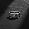Front view of handcrafted silver baroque scroll ring featuring detailed acanthus leaf relief on black stone background