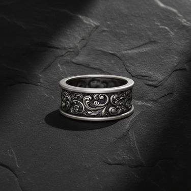 Front view of handcrafted silver baroque scroll ring featuring detailed acanthus leaf relief on black stone background