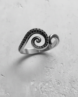 Side view of silver octopus ring showing spiral tentacle shape and textured suckers on white background