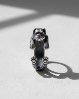 Front view of detailed silver dog ring featuring realistic pug face and paws resting on surface with shadow