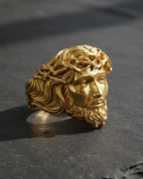 Gold-plated sterling silver Jesus Ring in a high-polish finish, with sharp light highlighting the intricate hair and beard details.