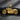 Gold vermeil motorcycle pendant with detailed V-twin engine and wheels on dark stone background
