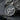 Close-up of the handcrafted gender symbol pendant resting on dark stone, highlighting the oxidized silver finish