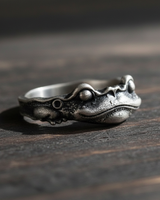 Side profile of silver frog prince ring showing the oxidized finish and wrap-around band design suitable for animal lovers
