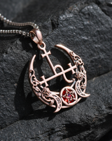 Rose gold plated Lilith Sigil Pendant featuring triple moon design and red stone detail on dark textured rock background