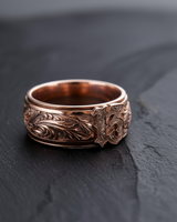 Rose gold plated variation of the Lucky 13 amulet ring with detailed relief engraving on slate background