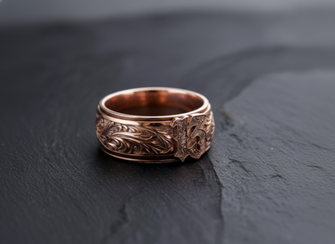Rose gold plated variation of the Lucky 13 amulet ring with detailed relief engraving on slate background