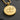 Macro detail of round 925 sterling silver LGBT pride pendant with gold finish resting on dark slate stone