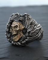 Side view of silver biker ring displaying gold-tone skull face and perched eagle design for men