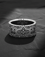 Detailed front view of 925 sterling silver gothic cross ring with floral engravings on black stone background