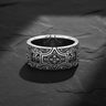 Detailed front view of 925 sterling silver gothic cross ring with floral engravings on black stone background