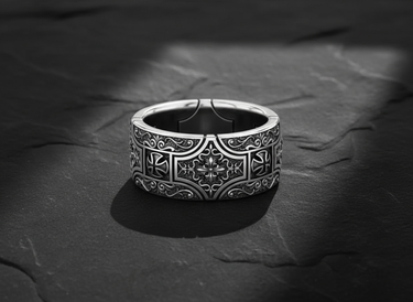 Detailed front view of 925 sterling silver gothic cross ring with floral engravings on black stone background
