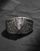 Detailed front view of 925 sterling silver wolf moon ring with oxidized finish on a textured black slate background