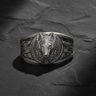 Detailed front view of 925 sterling silver wolf moon ring with oxidized finish on a textured black slate background