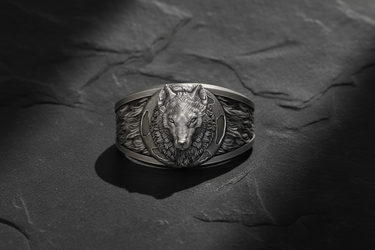 Detailed front view of 925 sterling silver wolf moon ring with oxidized finish on a textured black slate background