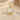 Gold vermeil silver leaf circle pendant shown on chain against soft beige fabric background