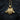 Gold vermeil variant of the three headed wolf pendant displayed on a rustic wooden log surface