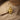 Gold variant of elephant Hamsa pendant displayed on sandy texture with driftwood background