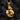 Close-up of the handcrafted curled fox pendant in rich gold finish resting elegantly on textured dark coal pieces