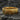Gold vermeil tree bark ring resting on dark stone highlighting the deep vertical grooves and rustic nature design