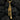 Detailed view of the trumpet pendant's flared bell and finger buttons set against a dark coal background.