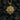 Close up of silver sun deity pendant with intricate carving and sterling silver texture against black coal background