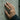 Circle pattern wedding ring worn on model, hand resting on concrete wall