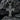 Close-up of the oxidized silver Jesus crucifix pendant resting on dark textured rock highlighting the metal artisanship