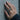 Mouse Wrap Ring worn on model hand against concrete wall background