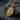 Close-up angled view of gold vermeil Saint Francis pendant on dark slate highlighting artisan craftsmanship