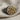 Close-up of handcrafted skull cluster ring showing intricate two-tone oxidized silver and gold finish on fabric