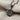 Leaf Twig Pendant, black rhodium, angled close-up view on fabric