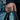Lifestyle shot of wide textured band ring worn on a man's hand holding a black leather bag in an urban setting.