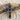 Close-up of gothic red stone cross pendant resting beautifully on weathered driftwood and light colored sand